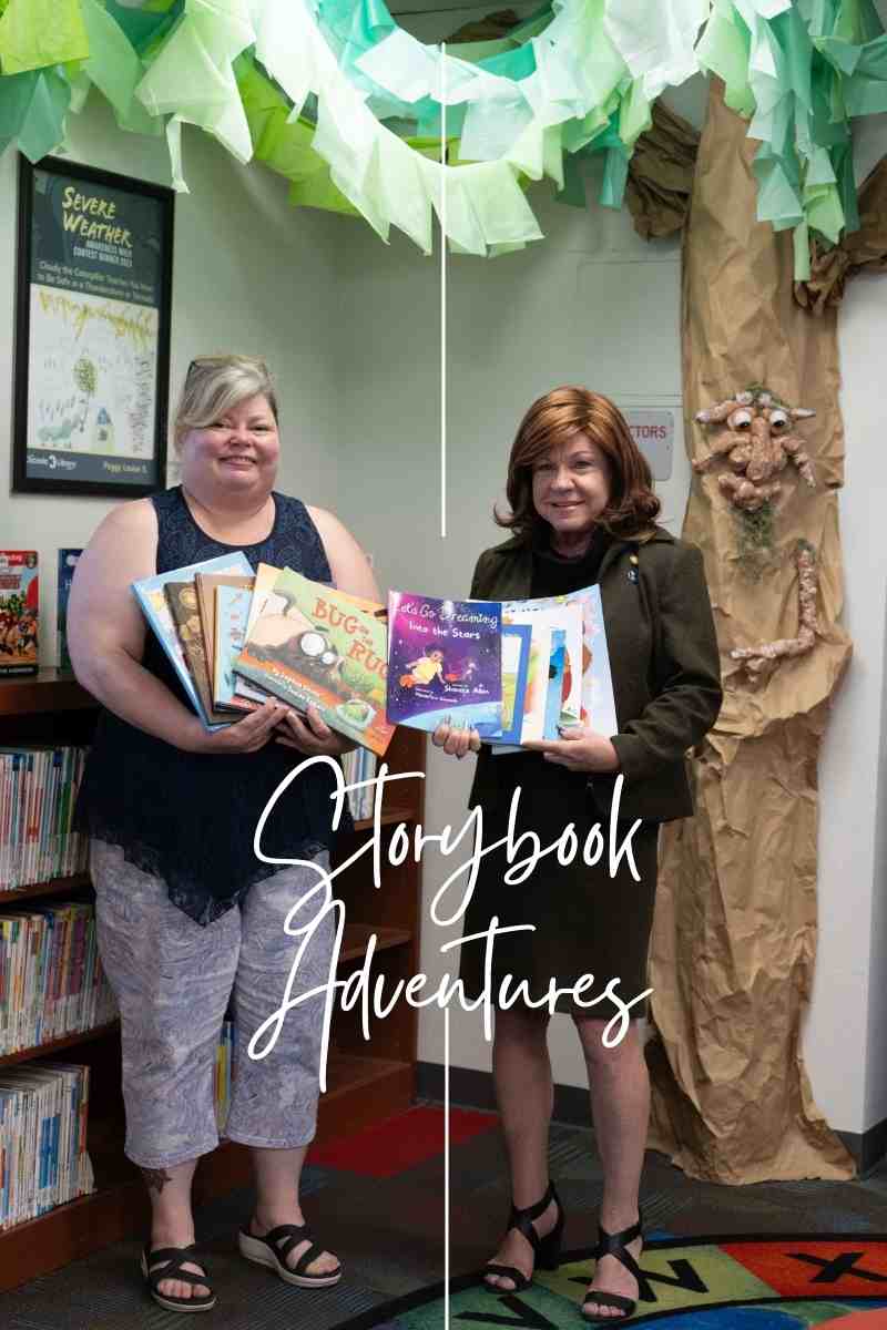 librarian and state representative stand next to each other under a paper tree holding childrens books